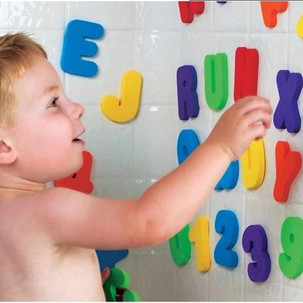Toddler exploring foam bath letter and number toys stuck to bathtub tiles