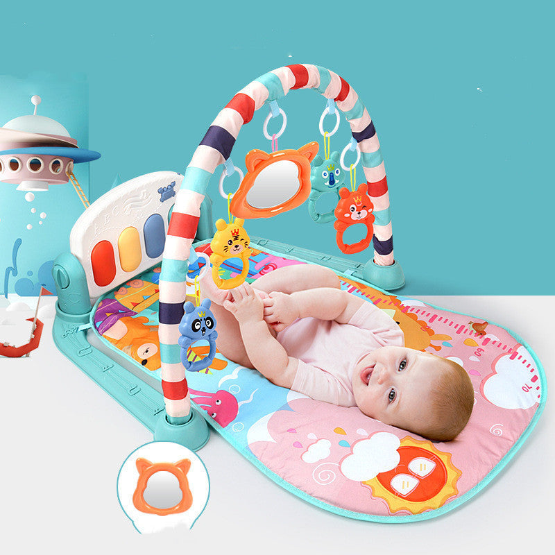 Newborn baby lying on Baby Activity Gym play mat kicking piano pedals with arched frame and hanging toys
