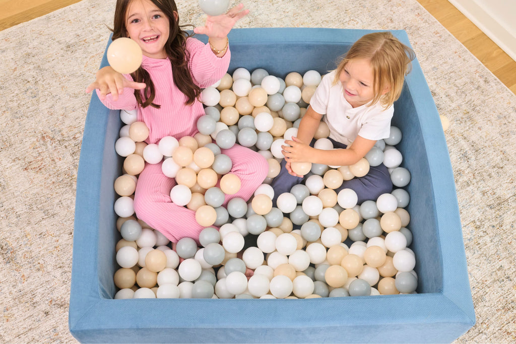 Young child playing in TumbleHouse Ball Pit Bundle blue ball pit showing 500 colorful balls
