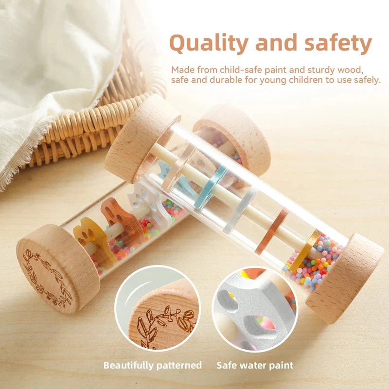 Smiling baby holding Montessori rain stick rattle toy showing easy-to-grasp size for small hands