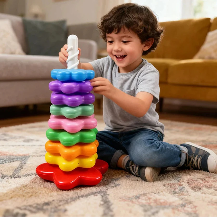 Toddler boy playing with Montessori rainbow stacking tower showing colorful spinning rings on white base