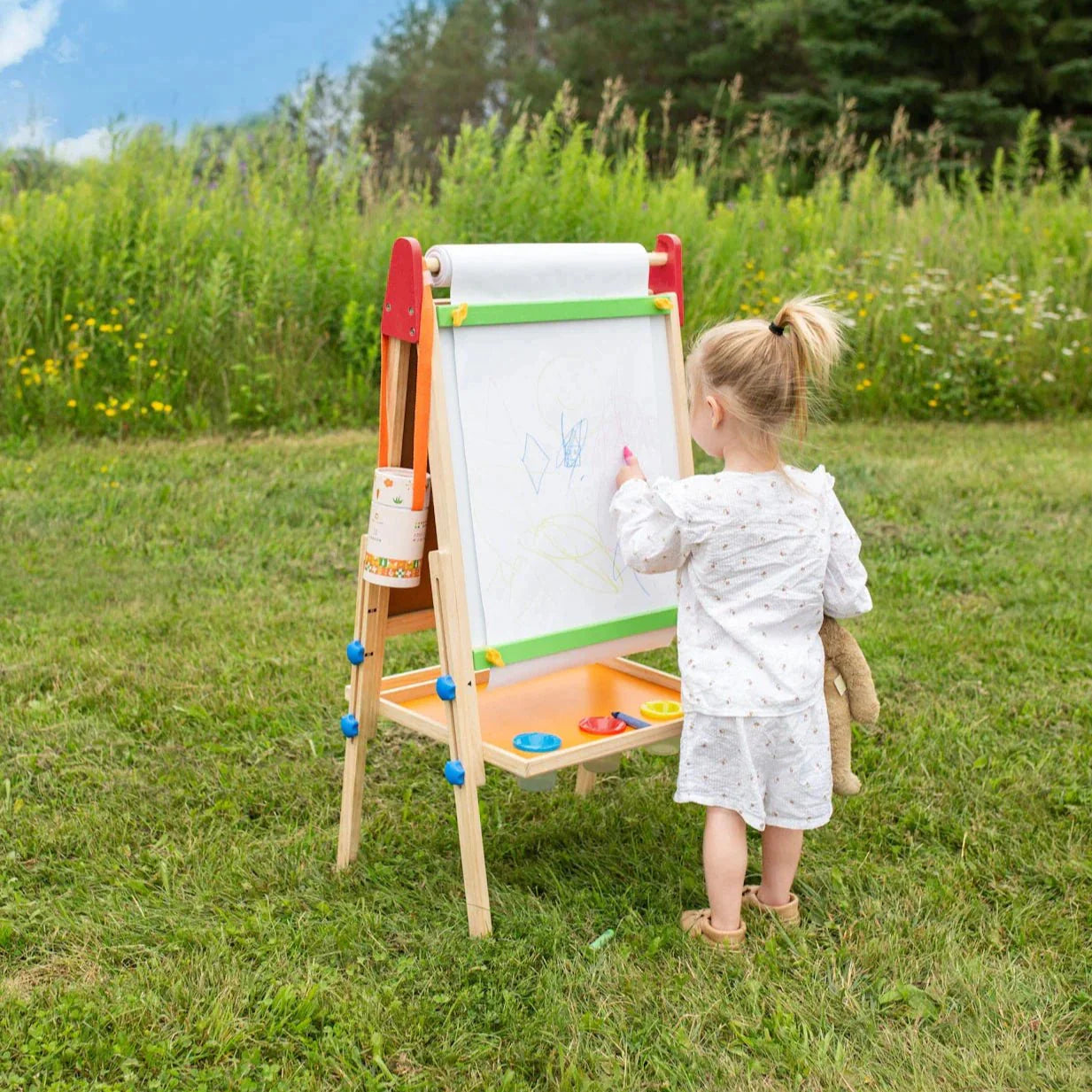 Child painting on Tiny Land art easel outdoors
Tiny Land easel showing full set of drawing tools included