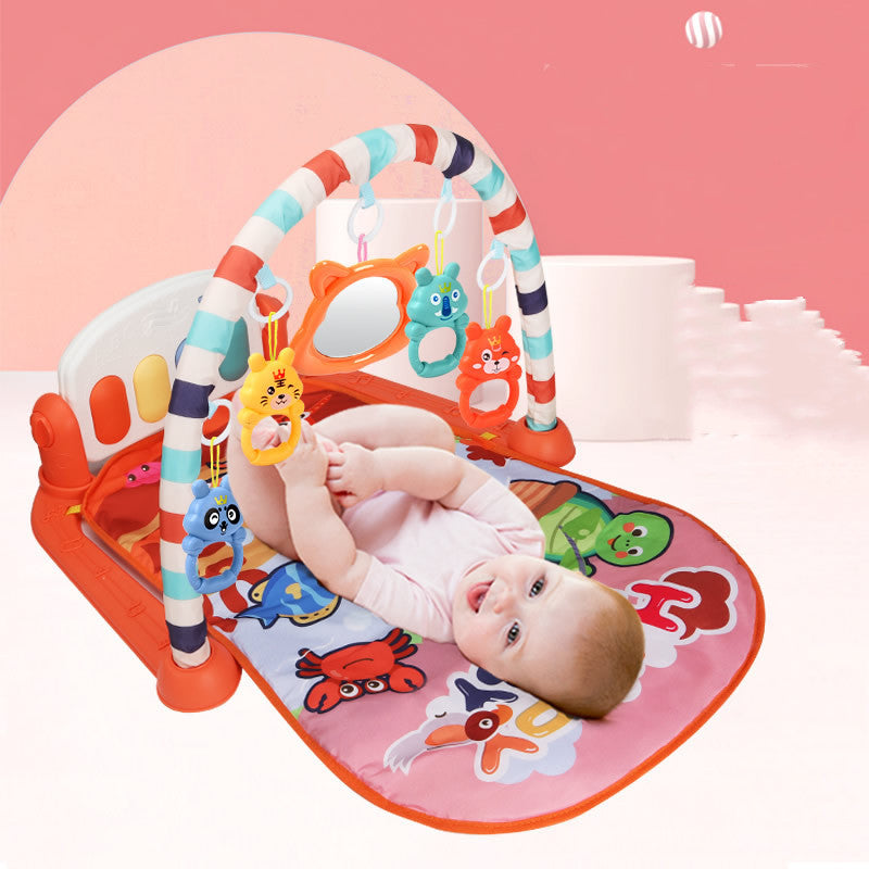 Newborn baby lying on Baby Activity Gym play mat kicking piano pedals with arched frame and hanging toys